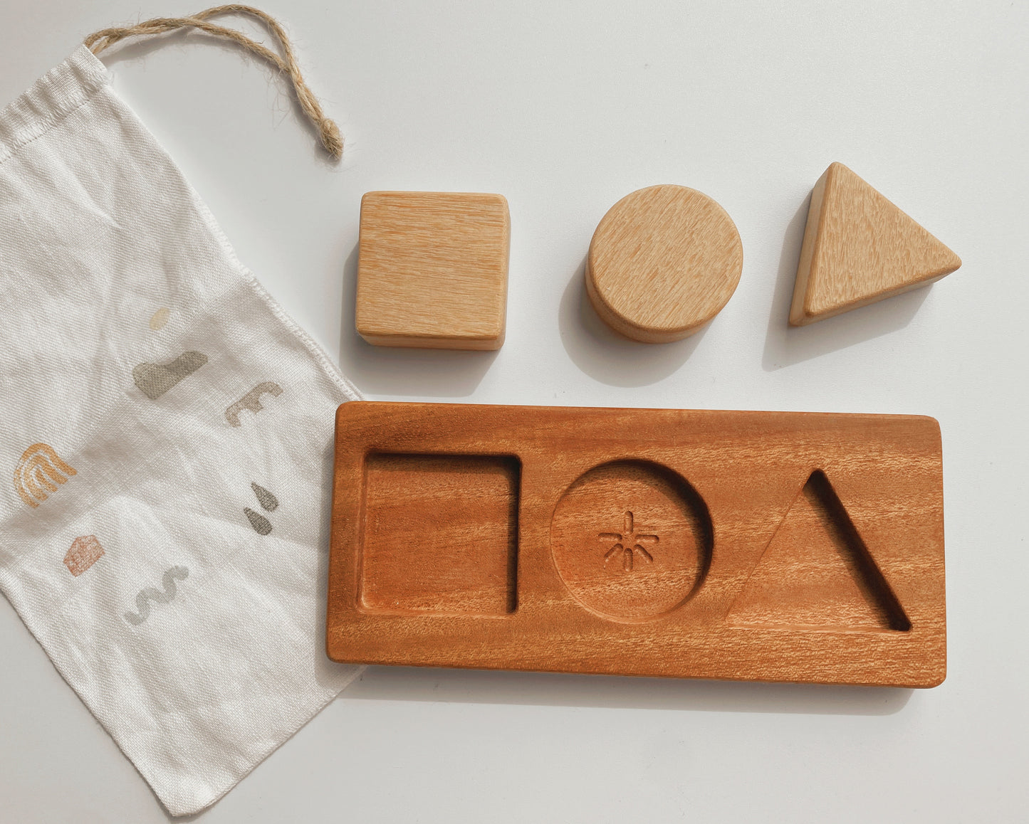Square, Circle, Triangle. The shapes puzzle enables the little ones to develop hand-eye coordination and visual perception skills. Each chunky shape is made from Tembusu wood allowing the tiniest hands to grasp and the board is made from African Mahogany (Khaya).